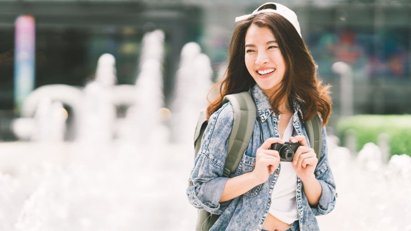 A person smiling outdoors, enjoying daily life